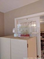 Seven quilting rulers displayed standing upright on a wooden holder, with black gridlines on clear acrylic rulers.