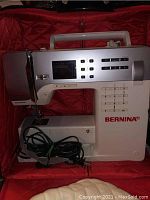 Front view of Bernina B350 sewing machine inside red-lined carrying case