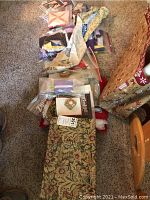 Full view of fabric pieces, cut and uncut, with sewing supplies in bags conceivably inside the box.