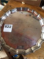 Top view showing scalloped edge and central engraved dedication