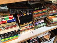 Books stacked on shelves including Dead Until Dark box set, The Book Thief, and other assorted titles.