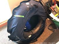 Inner tube slider in blue fabric cover with black handles and 'Lands' End' logo showing, placed on chair with visible life jacket inside tube.