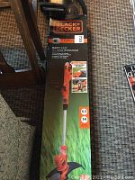 Black+Decker EasyFeed 14 inch corded electric string trimmer box, displaying front view of the product packaging with key specifications.