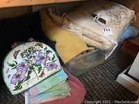 Electric blanket with controller, blankets, pillow, and kitchen linens including tea cozy and placemats