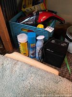 Handheld Dirt Devil vacuum, ceramic heater, cleaning chemicals bottle caps visible, and plastic stool partially visible