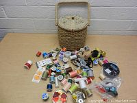 Overview of basket with sewing items spread out showing various threads and notions