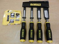 Set of four DeWalt chisels with yellow and black handles and metal blades, arranged in a black holder with DeWalt logo, with an informational insert.