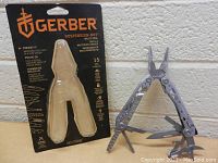 Gerber Suspension-NXT multi-tool in packaging and out, showing folded tool and open pliers with multiple fold-out tools extended.