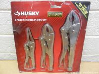 Front view of the 3-piece Husky locking pliers set in original red packaging with pliers visible.