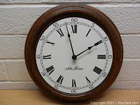 Front view of the vintage Seth Thomas wall clock showing the dial, Roman numerals, and wooden frame.