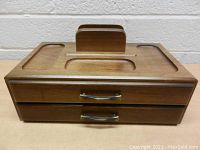 Front view showing wooden valet with two drawers and top compartments