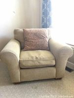 Front view of beige Sherrill Furniture armchair with reddish-brown throw pillow on it.