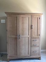 Front view of wooden computer desk with two large doors, one side door and three drawers.