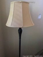 Close-up of beige fabric shade showing vertical segments and slight wear