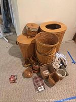Three tall woven wood baskets with fitted lids and one with cloth liner