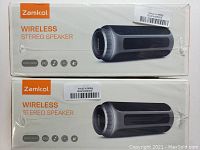 Two sealed boxes of Zamkol wireless stereo speakers showing front with product image and brand.