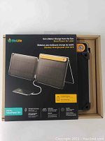 Front box showing foldable solar panels, USB cable, and on-board battery with orange trim.