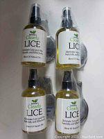 Four bottles of Isabella's Clearly Lice treatment arranged together, showing front label and packaging.