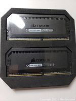 Two Corsair Dominator Platinum RGB DDR4 RAM sticks in black with Corsair logo, shown in foam packaging.