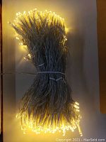 Four bundles of tightly coiled LED string lights with warm white bulbs and transparent wiring.