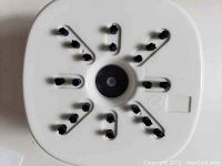 Bottom view of the mini vacuum cleaner showing black brush bristles arranged in rows on a white triangular base.