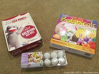 Lot showing the boxed Original Rockford Red Heel Sock Monkey Kit, boxed Botanical Enchanted Fairy Garden Craft Kit, and pack of 12 white hanging Easter eggs for painting.