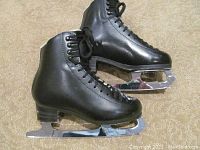 Side view of black leather figure skates showing blade and boot details