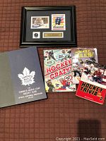 Photo of 4 hockey books and framed Phil Kessel collectible showing front covers and layout.