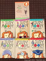 Set of 7 Judy Moody paperback books arranged in rows on a dark textured surface. Covers visible with colorful, illustrated art and text.