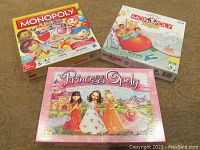Three boxed children's board games: Monopoly Junior Party, Monopoly Junior, and PrincessOply.