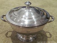 Pewter bowl with lid on, showing side handles and footed base, branding '55 Park Lane' stamp visible on lid and bowl.
