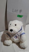 Front view of white plush bear in Blue Jays jersey showing face and logo on shirt
