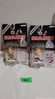 Two NHL Headliners collectible hockey figures of Joe Thornton and Wayne Gretzky in original blister packaging side by side.