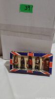 Boxed set of five London souvenir figurines including Horse Guard, Policeman, Sentry, Lifeguard, and Horse Guard, in clear display packaging with Union Jack design.
