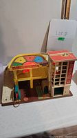 Photo of vintage Fisher Price parking ramp and service center toy showing the side view with structure and ramp.
