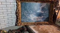 Full view of the large vintage picture frame with ornate decorative design and landscape artwork inside.