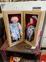 Full view of both Raggedy Ann and Andy dolls displayed together in original cardboard boxes with plastic window front covers.