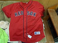 Full front view of red Red Sox jersey with multiple autographs
