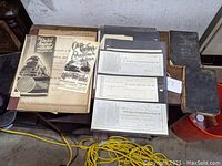 Table displaying all items including booklets, folded schedule, checks, and ephemera laid out