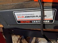 Close-up of machine label showing 5/8 HP, 16,000 cuts per minute, 4 1/8″ capacity and Sears Craftsman logo