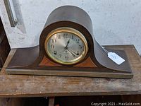 Front view of vintage Seth Thomas mantle clock showing dark wood case with angled edges and silver clock face with Arabic numerals and black hands.