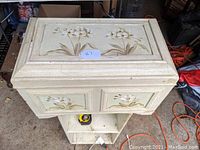 Top view of the small wooden chest showing raised floral painted design on lid and front panels