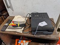 Sony EV-C3 player with remote, RCA cables, and user manual on wooden surface, angled view