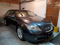 Front left three-quarter view of car parked in garage