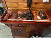 Tray with multiple carved wooden masks and talisman