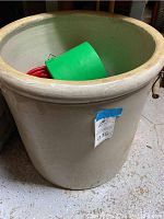 Front and inside view of the large ceramic crock showing part of the interior and some contents.
