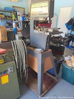 Full view of the large Sears Craftsman 12 inch band saw-sander mounted on a metal and wood stand in workshop setting, showing the size and build of the machine.