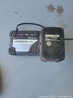 A black and silver Hitachi battery charger with label showing model UC 18YRL, cord and plug visible.