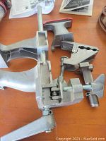 Photo of two heavy duty clamps, one pipe clamp and one C-clamp on wooden surface with papers nearby.