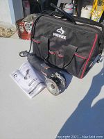 Photo showing RotoZip rotary tool with circular blade, Husky brand carrying bag, and instruction manual.
